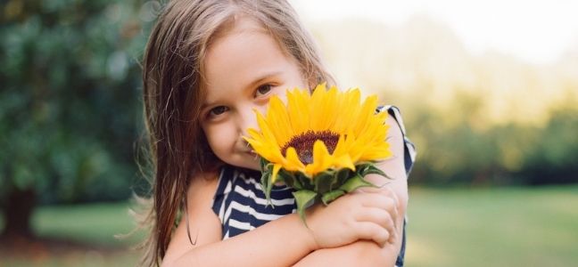 A photo of a young girl with a sunflower