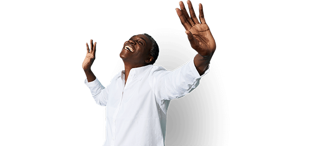 man in white shirt holding his hands up in joy
