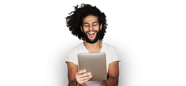 man in white tee looking at ipad with smile on his face
